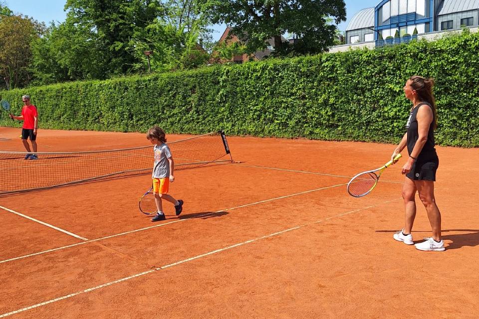 TC 1913 Düsseldorf e. V. - Eine Erwachsene Frau und ein Kind gemeinsam auf einem Tenniscourt