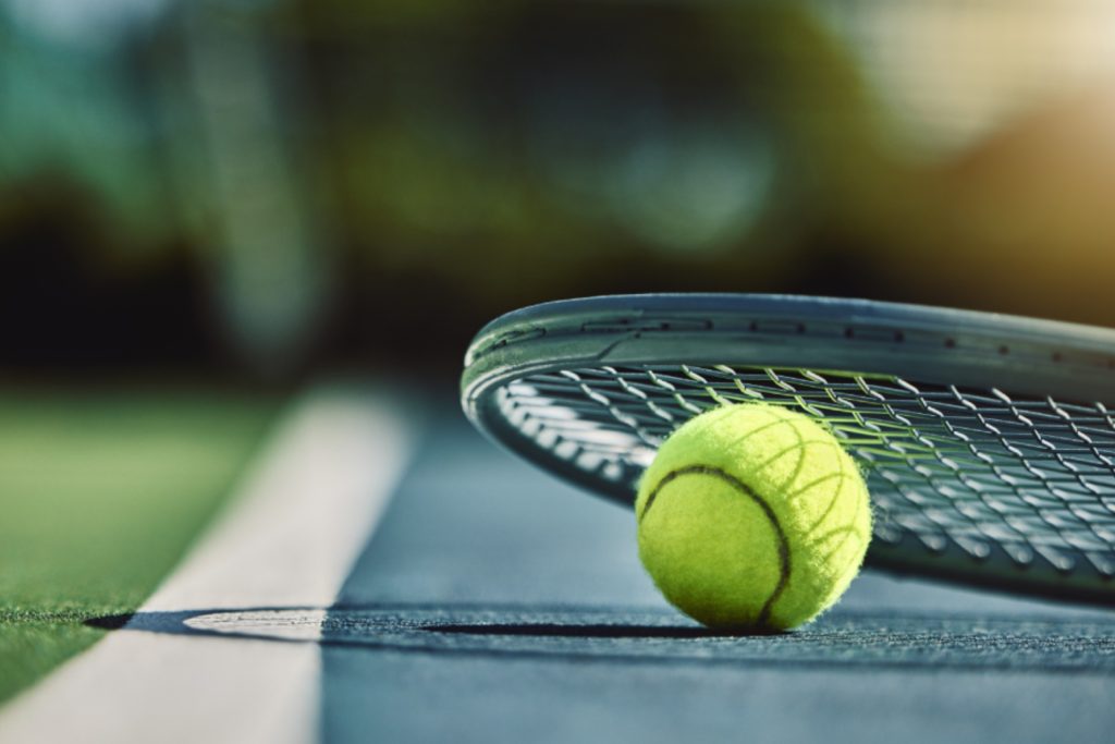 TC 1913 Düsseldorf e. V. - Ein Tennisball unter einem Schläger auf dem Court